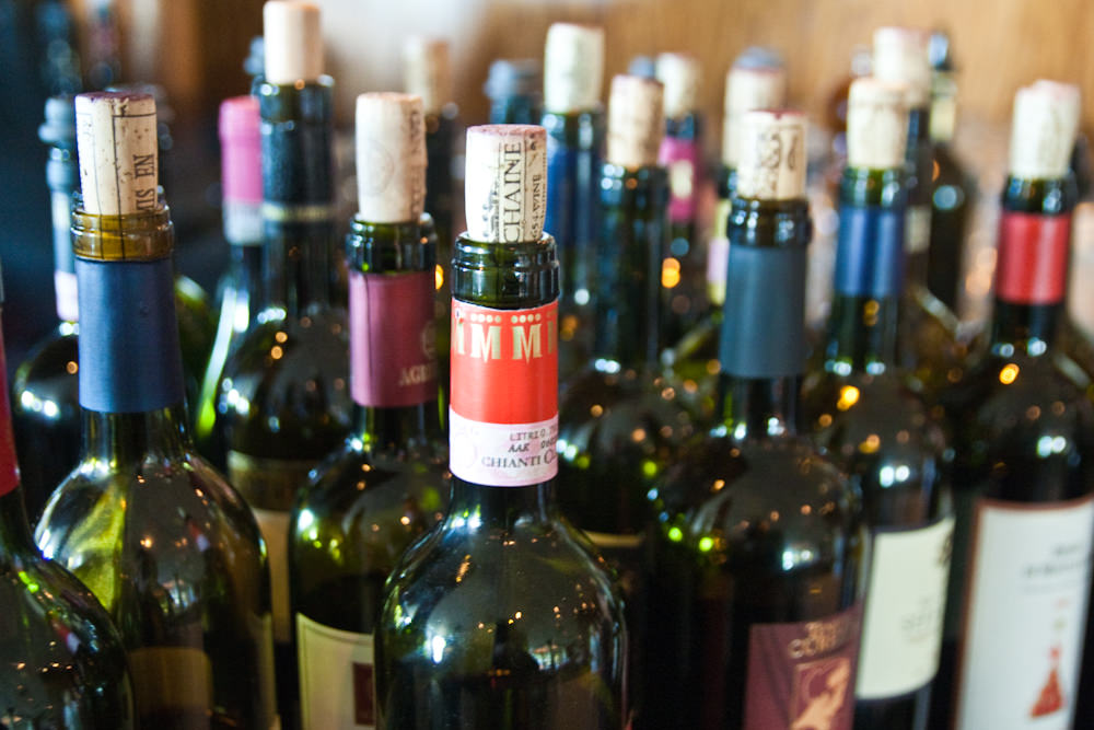 Uncorked wine bottles side by side — choosing a low-tannin variety makes red wine immediately softer and more approachable