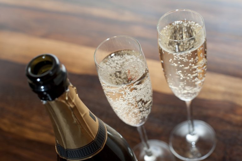 Two Champagne flutes raised in celebration — non-vintage Champagne is designed to be opened and enjoyed now, balanced and consistent year after year