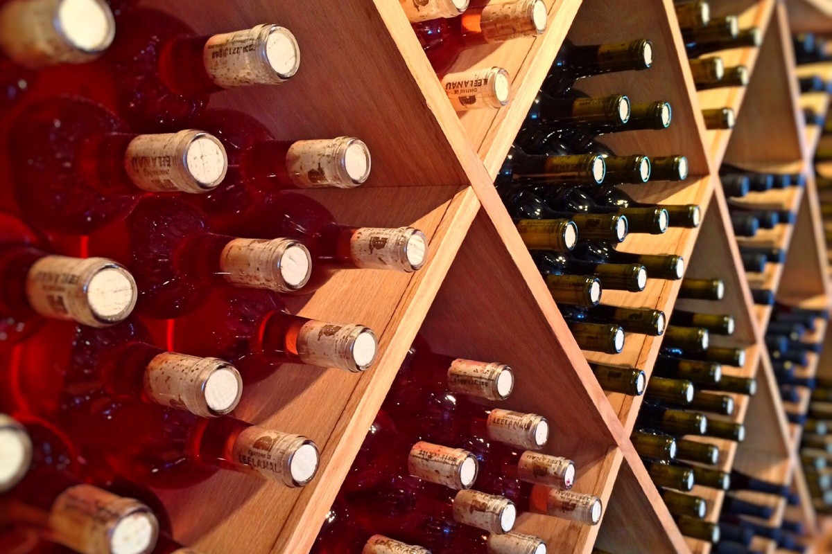 Wine bottles stored in a wooden cellar — many underrated wines age beautifully