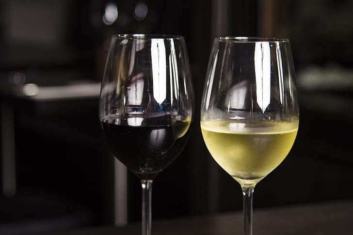 A row of wine glasses showing different wine colours from pale white through rosé to deep red — each colour reveals something about how the wine was made