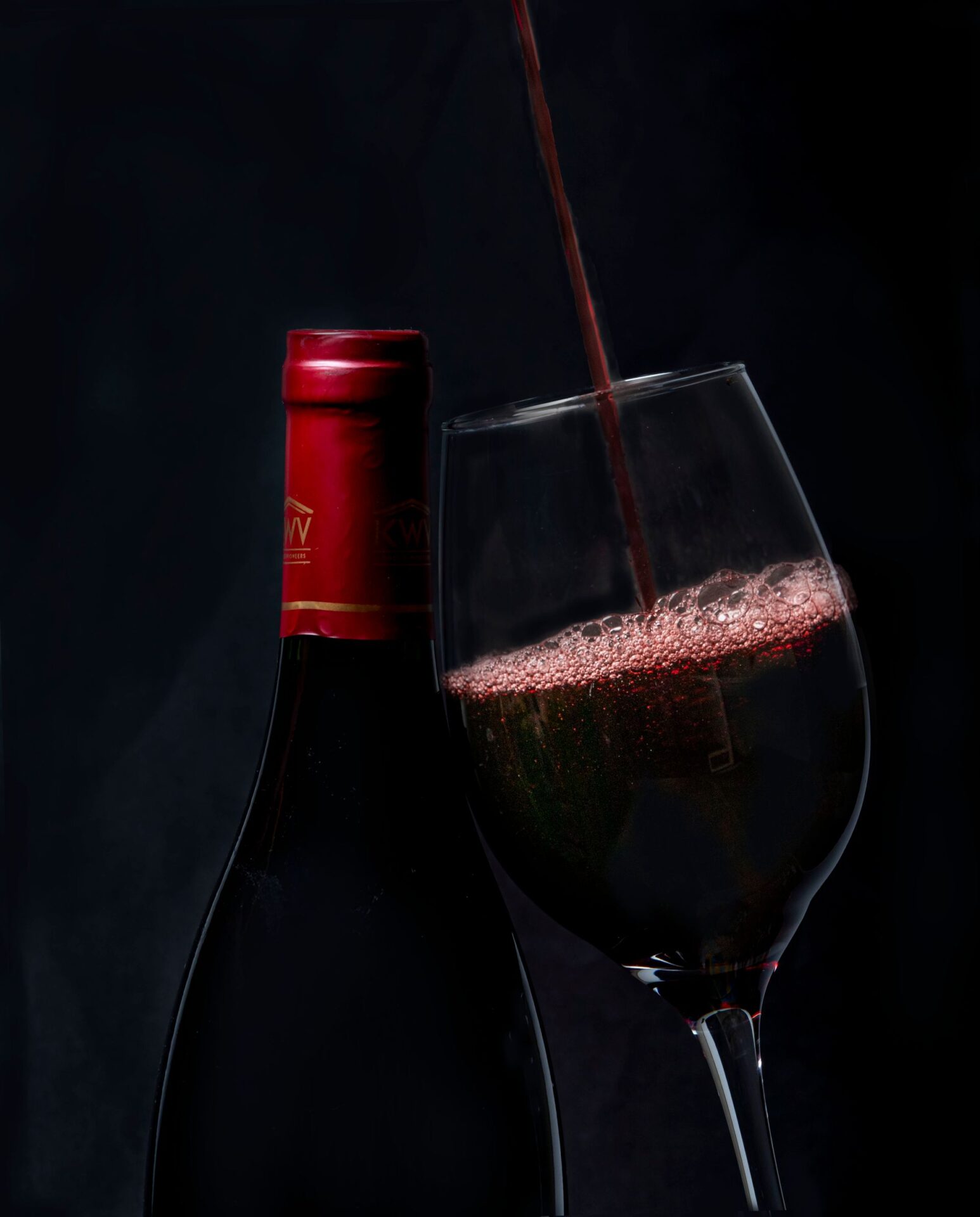 A glass of wine held up in a vineyard — natural wine begins with organic or biodynamic farming before the minimal-intervention approach continues into the cellar