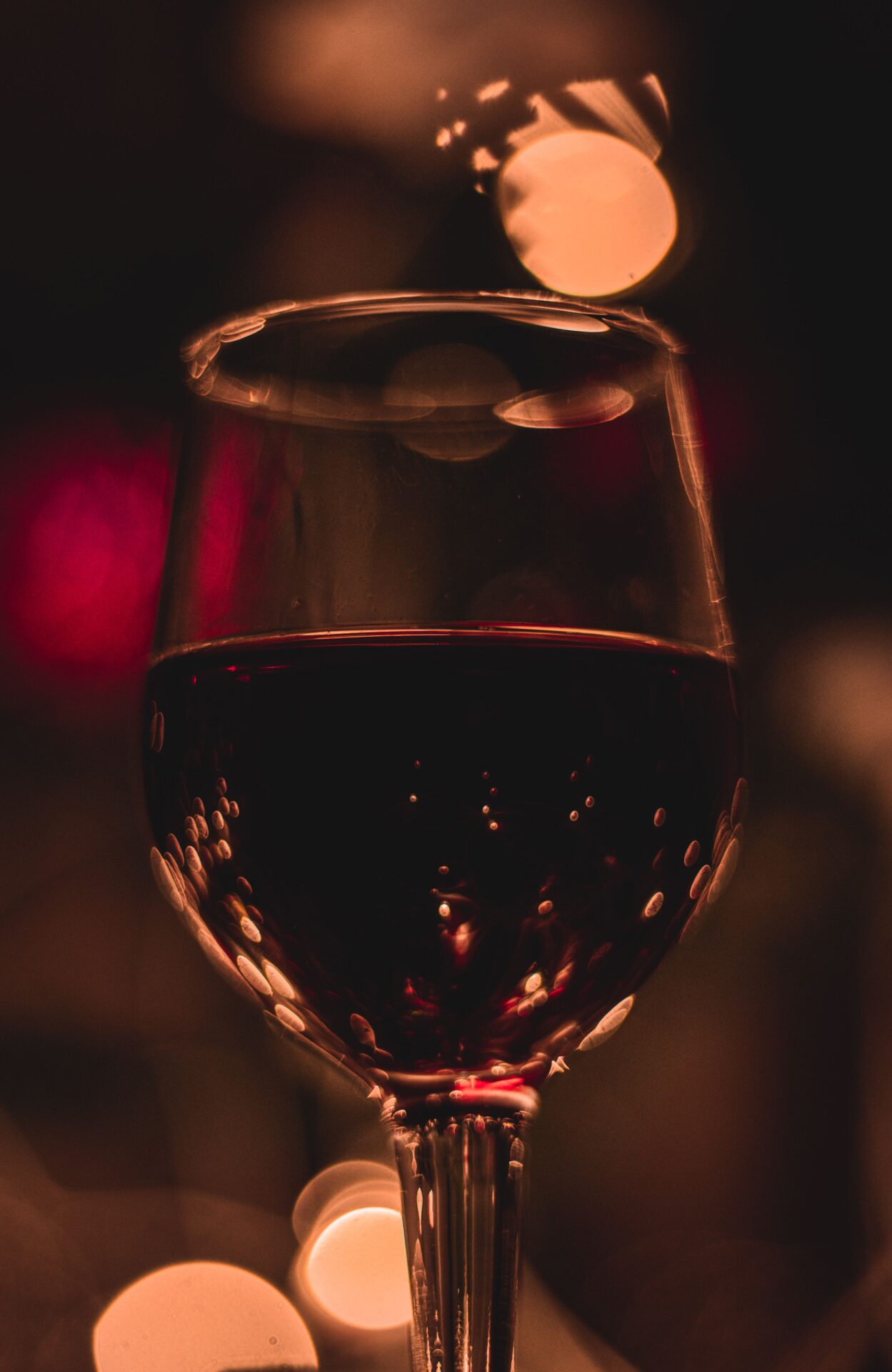 A glass of red wine in warm, elegant light