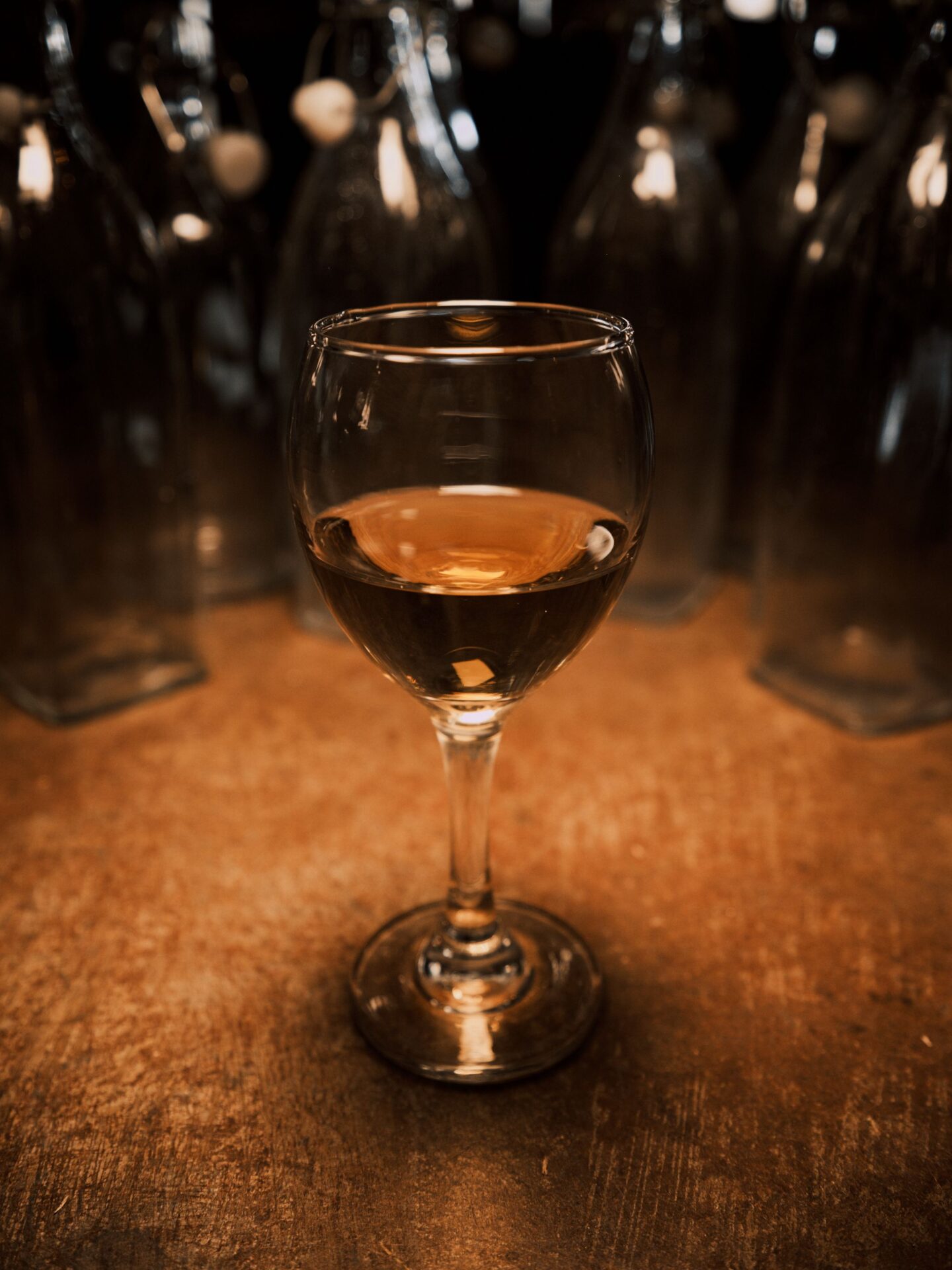 A glass of amber dessert wine on a rustic wooden table